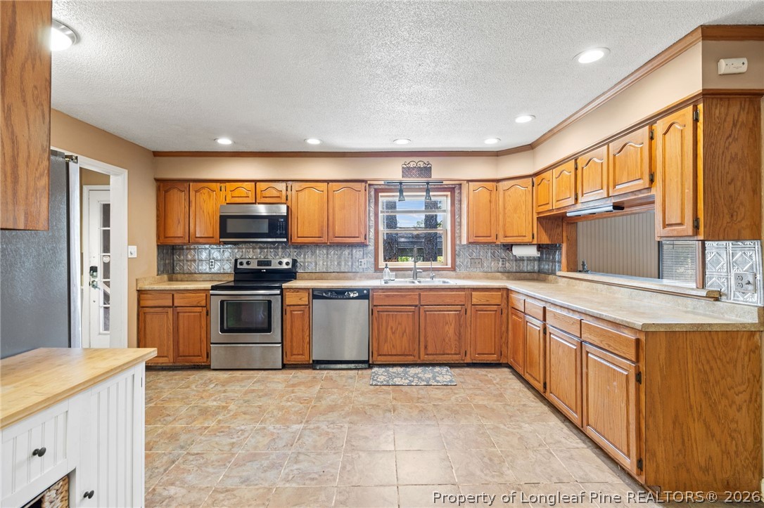 5605 MacGregor Court Fayetteville, NC 28304 - Photo 14 of 49 a kitchen with stainless steel appliances granite countertop a stove sink and cabinets