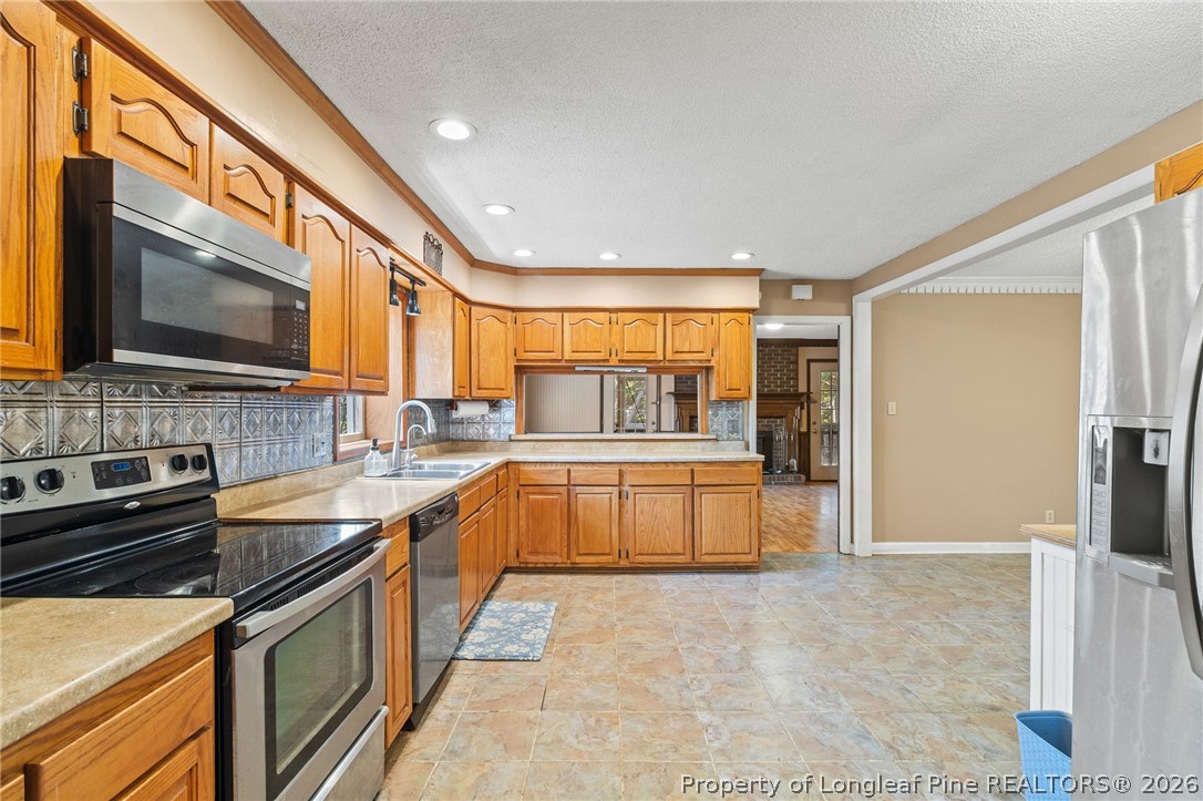 5605 MacGregor Court Fayetteville, NC 28304 - Photo 15 of 49 a kitchen with stainless steel appliances granite countertop a stove a sink and a microwave