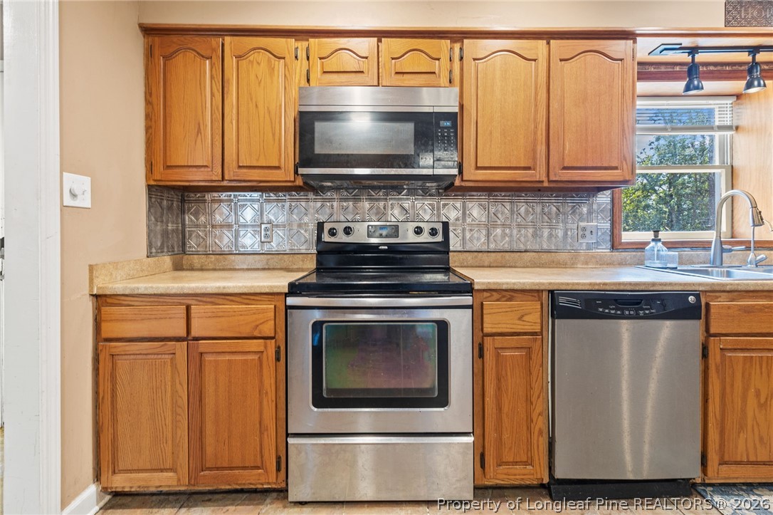 5605 MacGregor Court Fayetteville, NC 28304 - Photo 16 of 49 a kitchen with stainless steel appliances granite countertop a stove and a microwave