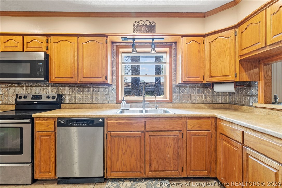 5605 MacGregor Court Fayetteville, NC 28304 - Photo 17 of 49 a kitchen with granite countertop a sink and a stove