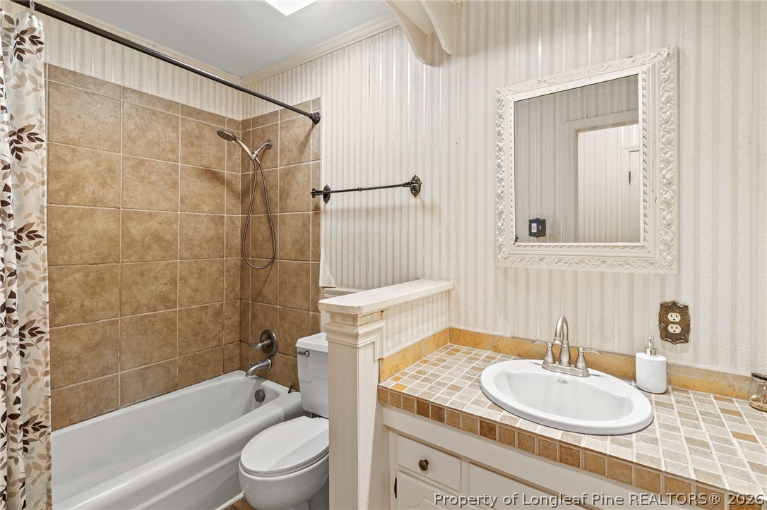5605 MacGregor Court Fayetteville, NC 28304 - Photo 30 of 49 a bathroom with a granite countertop sink toilet a mirror and shower