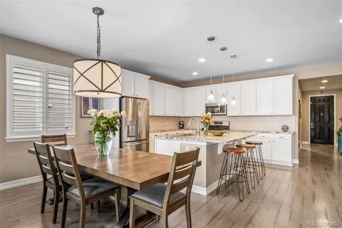 a view of a dining room and livingroom with furniture wooden floor a chandelier