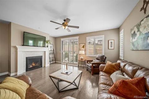 a living room with furniture ceiling fan and a fireplace