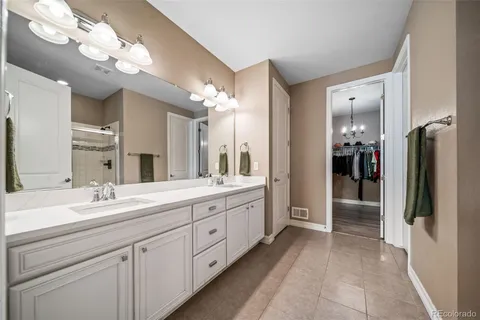a spacious en suite bathroom with a double vanity sink and a mirror