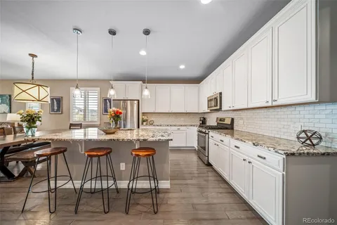 a kitchen with stainless steel appliances kitchen island granite countertop a stove a sink and a refrigerator