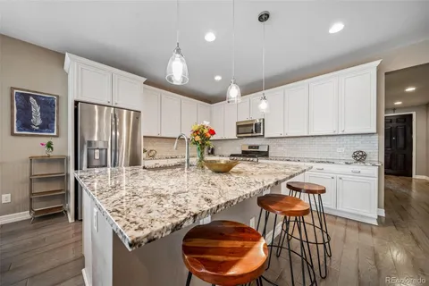 a kitchen with stainless steel appliances granite countertop a stove refrigerator sink and cabinets