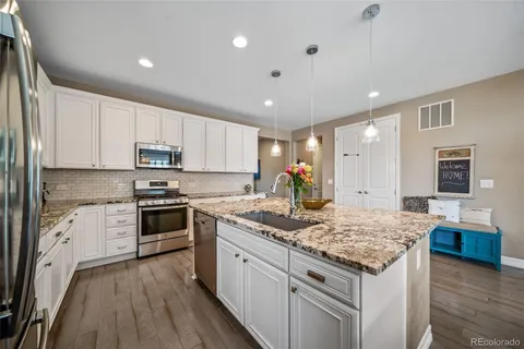 a kitchen with granite countertop kitchen island cabinets and wooden floor