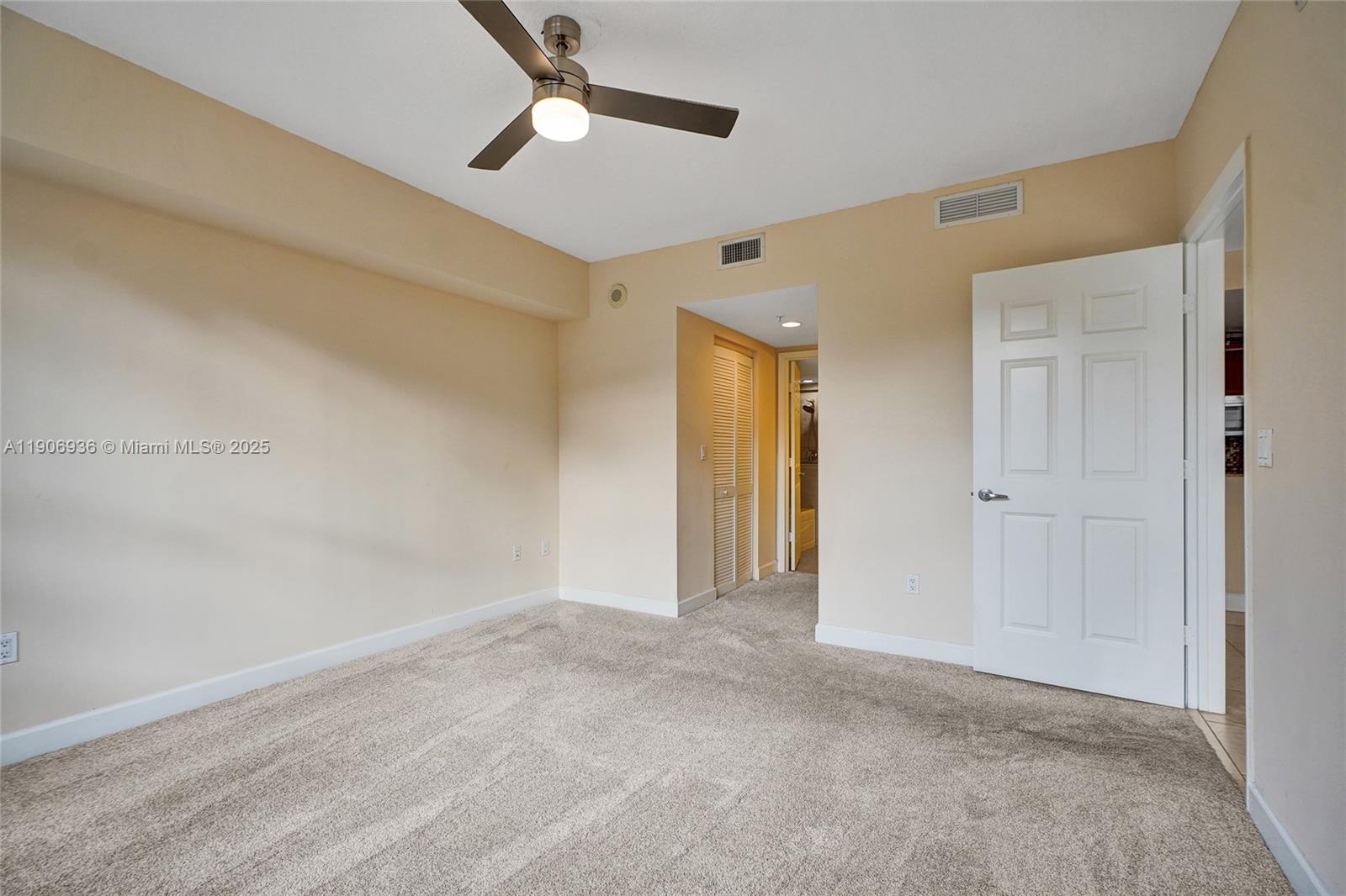 55 Merrick Way, Unit 619 Coral Gables, FL 33134 - Photo 18 of 40 a view of an empty room and a ceiling fan