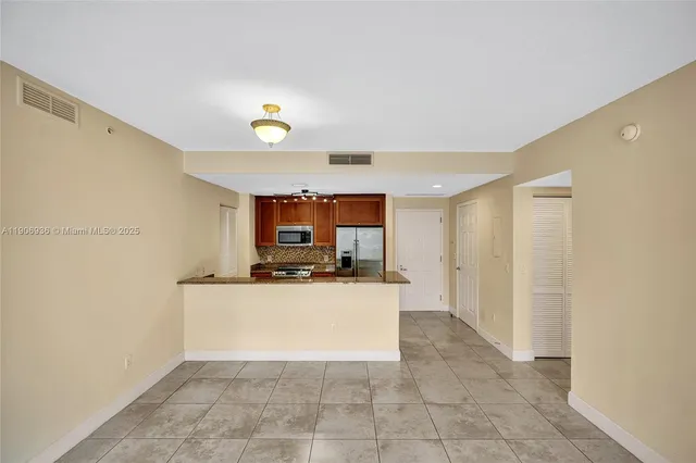 a view of a kitchen with a sink and a refrigerator