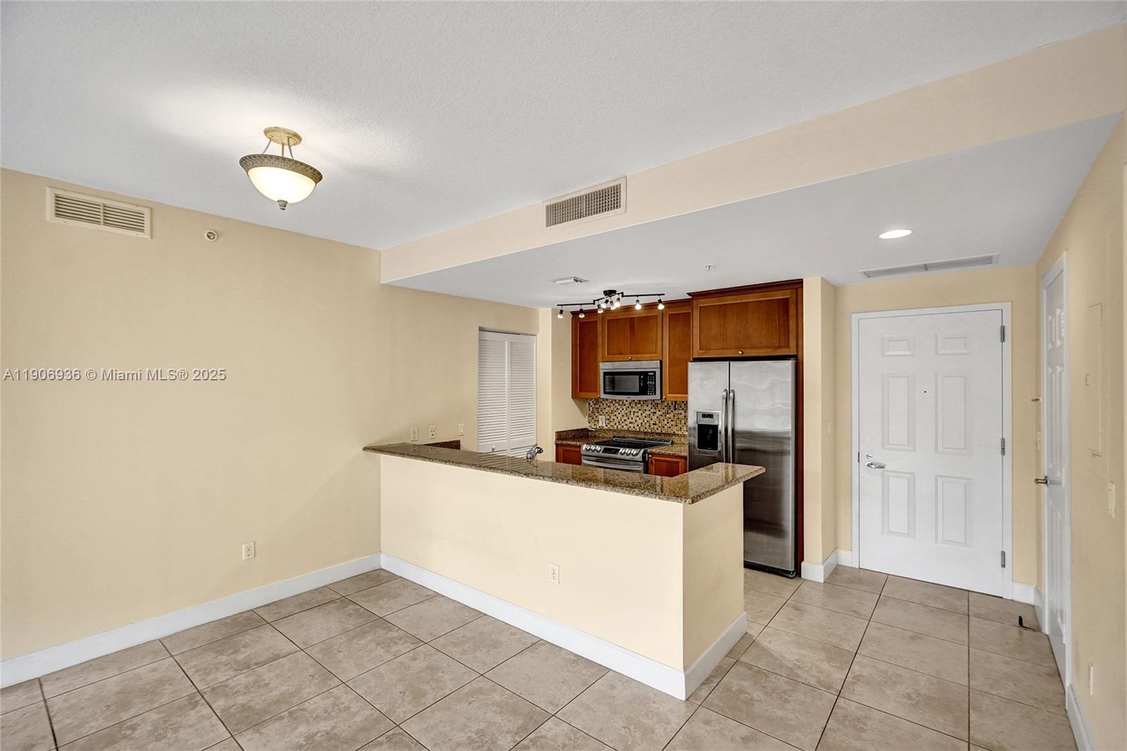 55 Merrick Way, Unit 619 Coral Gables, FL 33134 - Photo 6 of 40 a kitchen with a stove a sink and a refrigerator