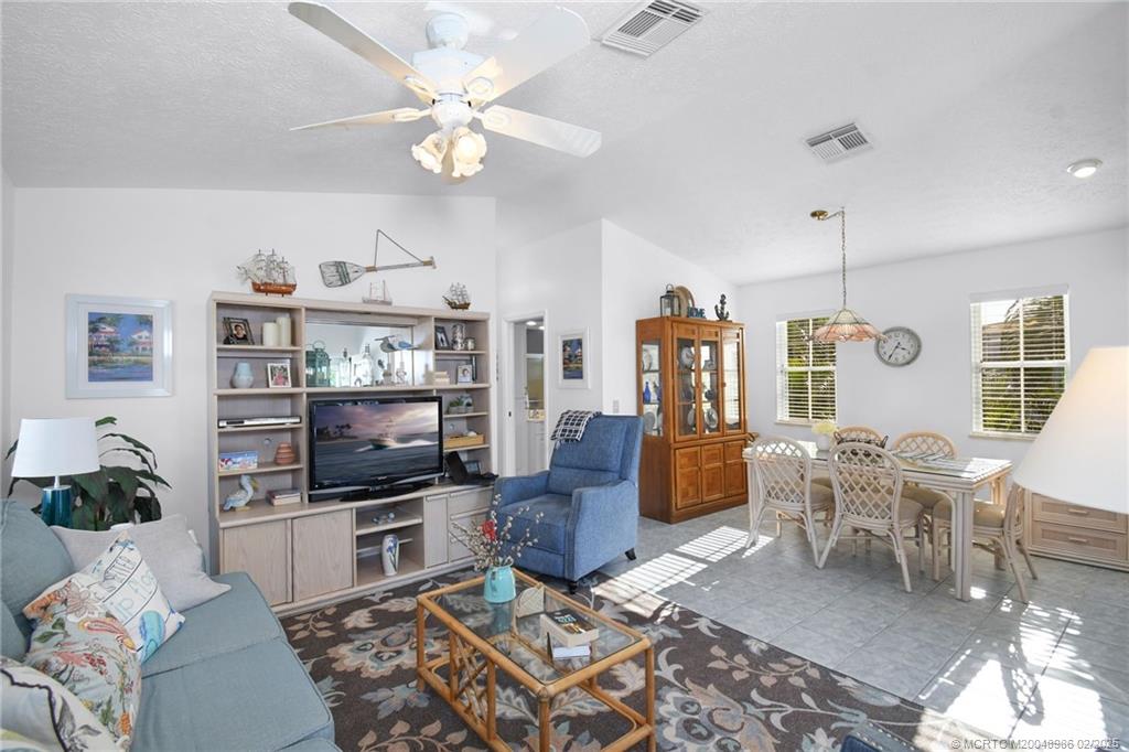 10725 South Ocean Drive, Unit 214 Jensen Beach, FL 34957 - Photo 14 of 90 a living room with furniture a chandelier and a flat screen tv