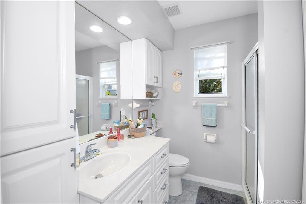 10725 South Ocean Drive, Unit 214 Jensen Beach, FL 34957 - Photo 25 of 90 a bathroom with a sink toilet vanity and window