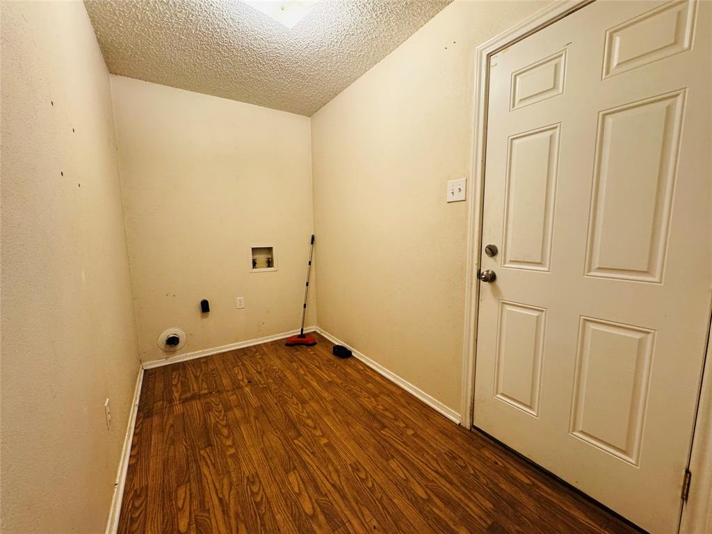 721 Mackey Ranch Road Bruceville-Eddy, TX 76524 - Photo 10 of 33 Utility room with wood-finish flooring, a paneled door, and ceiling lighting