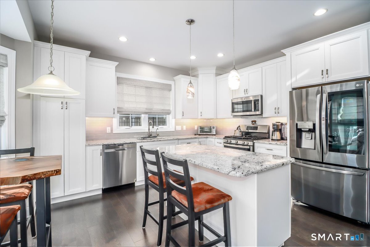 32 Hunting Ridge Lane, Unit 32 Bethel, CT 06801 - Photo 14 of 39 a kitchen with kitchen island granite countertop a sink a stove a refrigerator cabinets and chairs