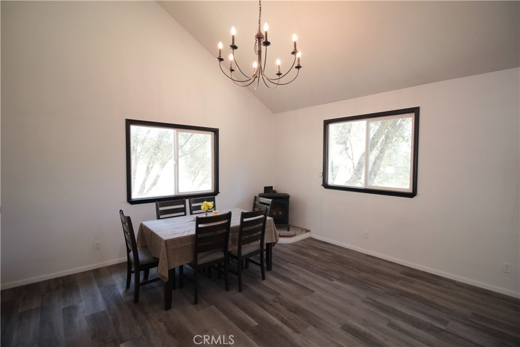 3616 Manzanita Road Mariposa, CA 95338 - Photo 9 of 18 a dining room with wooden floor a chandelier a wooden table and chairs