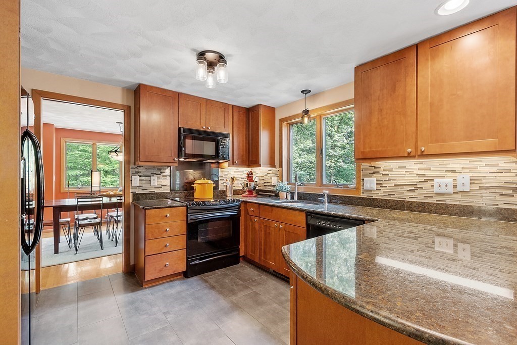 377 Sargent Road Boxborough, MA 01719 - Photo 5 of 42 a kitchen with granite countertop a stove top oven sink and cabinets