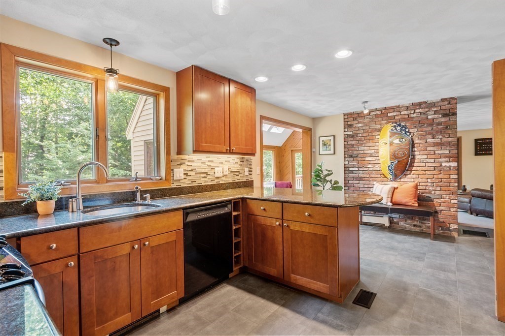 377 Sargent Road Boxborough, MA 01719 - Photo 8 of 42 a kitchen with stainless steel appliances granite countertop sink stove and wooden cabinets
