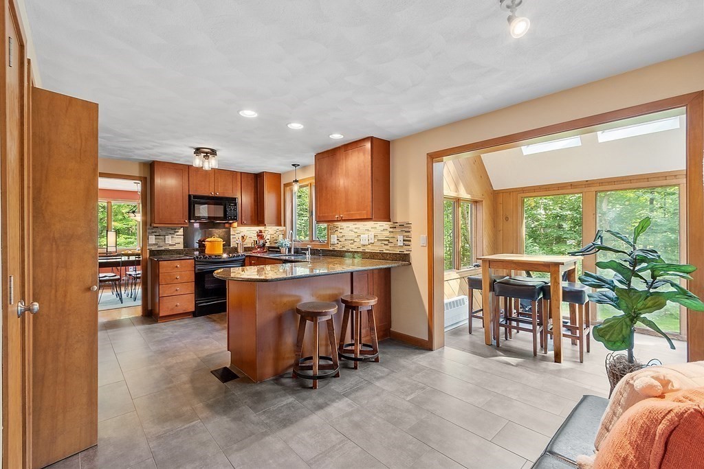 377 Sargent Road Boxborough, MA 01719 - Photo 9 of 42 a kitchen with a table chairs refrigerator and cabinets