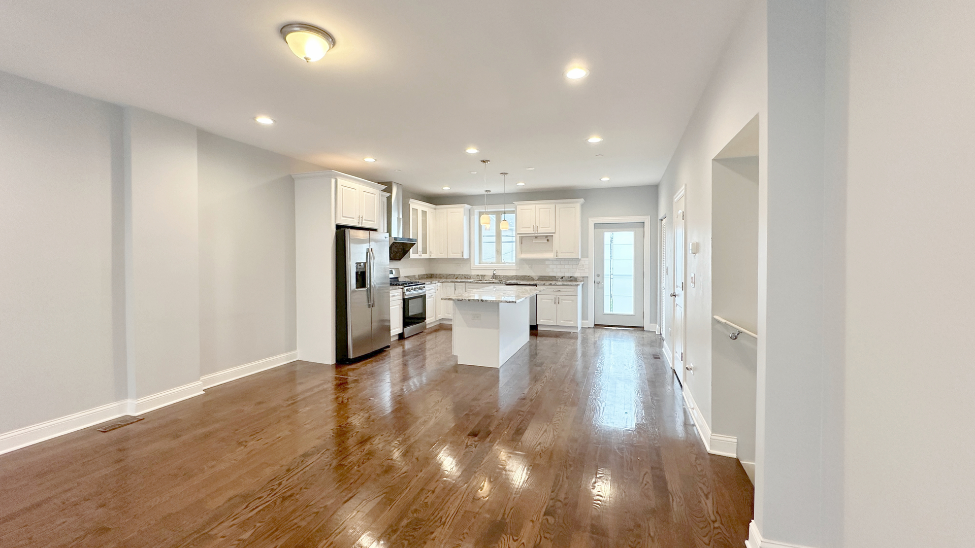 1538 West 34th Street, Unit E Chicago, IL 60608 - Photo 6 of 33 a view of a kitchen with kitchen island a sink wooden floor and stainless steel appliances