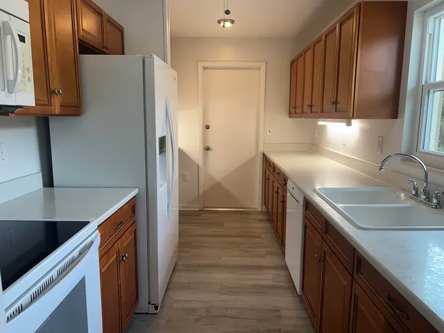 a kitchen with granite countertop a sink stove and refrigerator