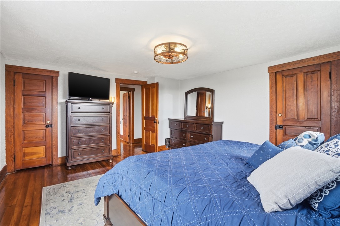 6155 North Union Road Clayton, OH 45315 - Photo 32 of 59 This spacious bedroom features warm hardwood floors and classic wooden doors, creating a welcoming atmosphere.