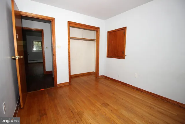 a view of an empty room with closet and a window