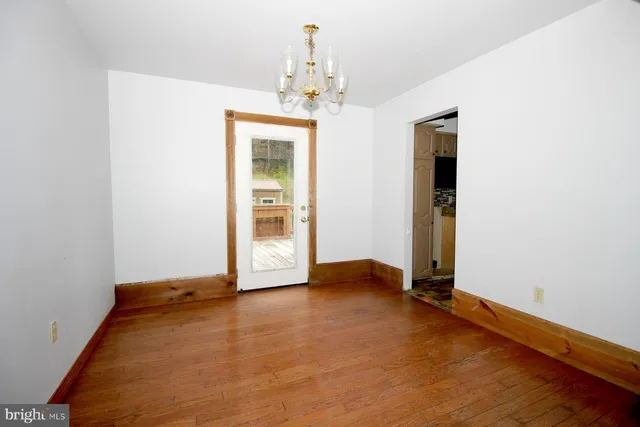an empty room with kitchen and windows
