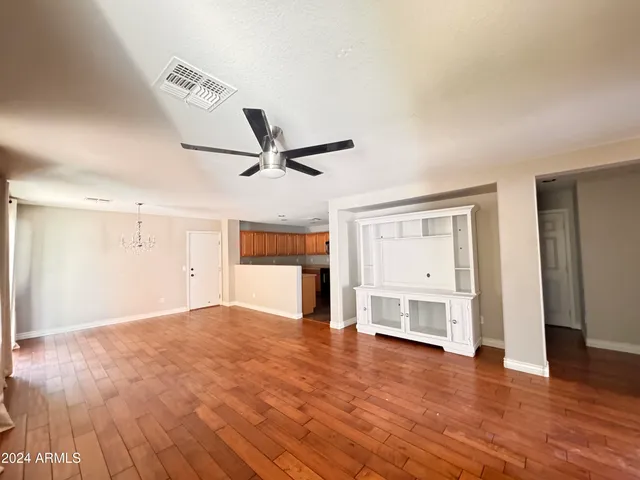 a view of empty room with wooden floor and window