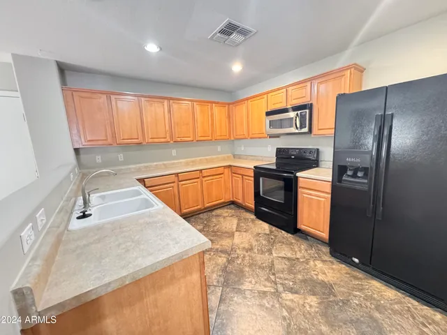 a kitchen with granite countertop a sink stainless steel appliances and cabinets