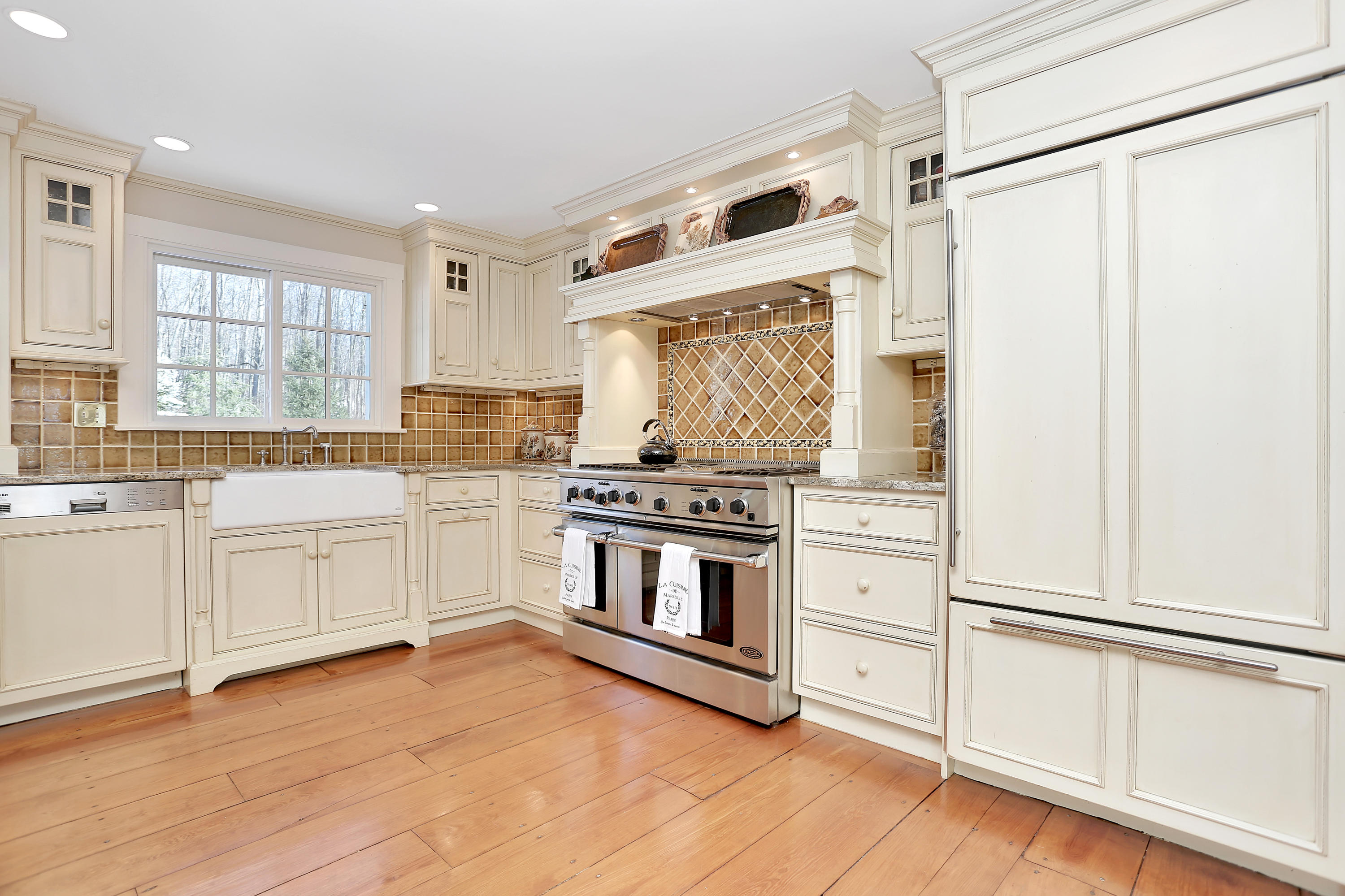 231 Turtle Back Road New Canaan, CT 06840 - Photo 7 of 22 a kitchen with white cabinets and white appliances