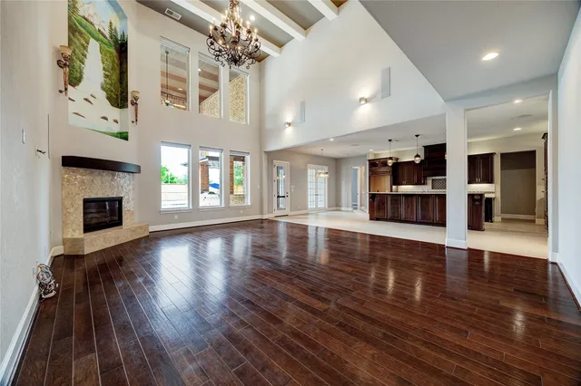 a view of an empty room with wooden floor and a fireplace