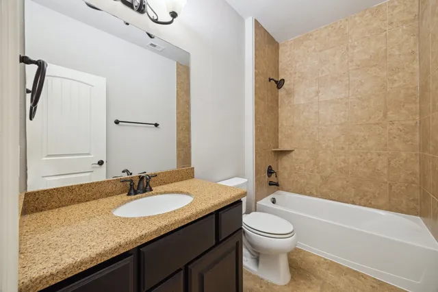 a bathroom with a granite countertop sink toilet a shower and a mirror