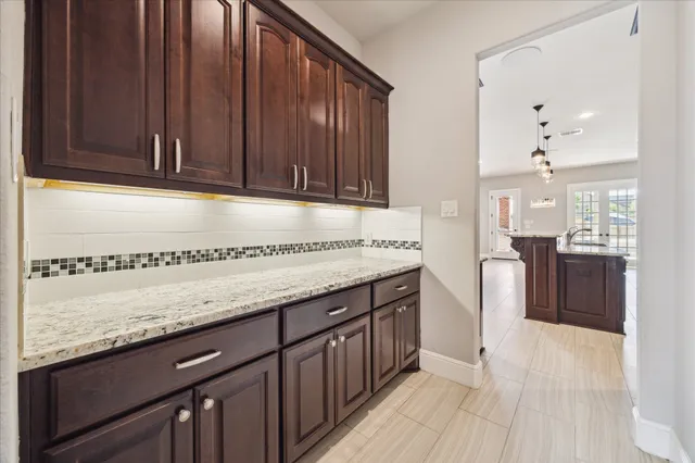 a kitchen with granite countertop wooden cabinets a sink and dishwasher