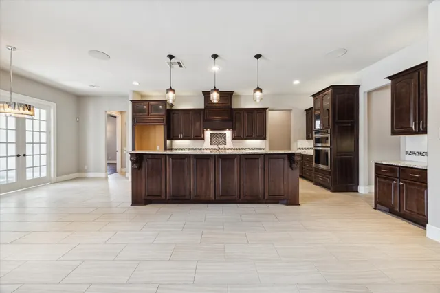 a kitchen with stainless steel appliances kitchen island granite countertop a refrigerator and a stove top oven