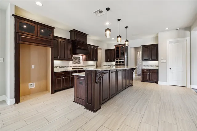 a kitchen with stainless steel appliances kitchen island granite countertop a stove top oven and sink