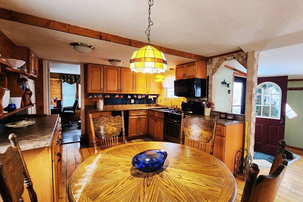3040 Cranberry Highway, Unit 34 Wareham, MA 02538 - Photo 2 of 14 a kitchen with stainless steel appliances granite countertop a stove a refrigerator a oven a sink with a dining table and chairs