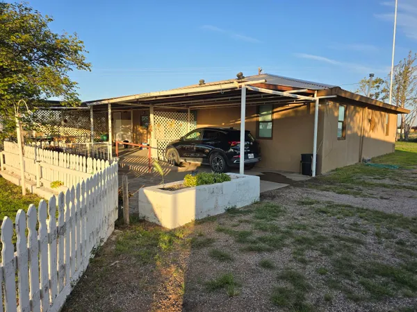 a view of a backyard with wooden fence and a bench
