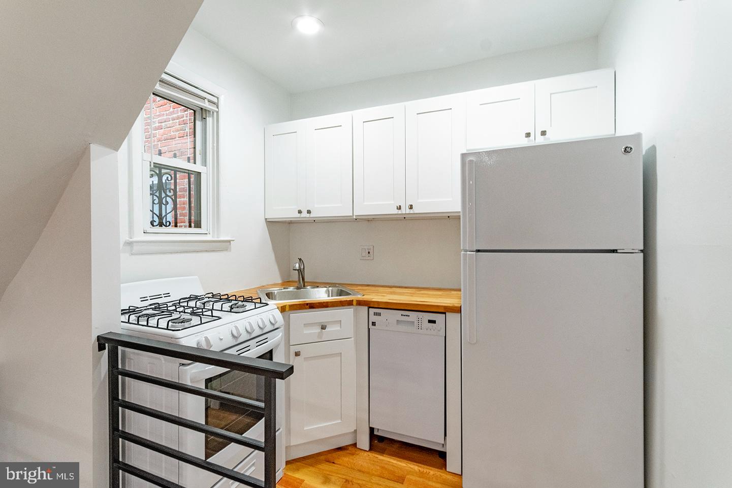 1516 Addison Street Philadelphia, PA 19146 - Photo 3 of 10 a kitchen with stainless steel appliances granite countertop a refrigerator sink stove and white cabinets