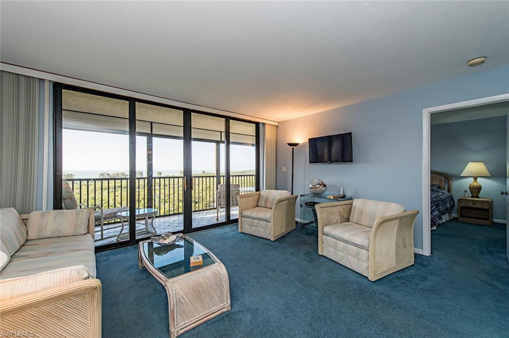 17 Bluebill Avenue, Unit 1102 Naples, FL 34108 - Photo 4 of 12 a living room with furniture and a flat screen tv