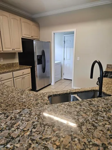 a kitchen with granite countertop a refrigerator and a sink