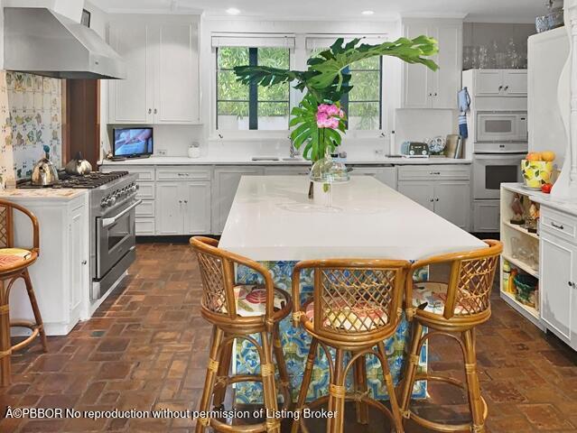 Undisclosed Address Palm Beach, FL 33480 - Photo 7 of 33 a kitchen with stainless steel appliances kitchen island granite countertop a table chairs in it and wooden floor