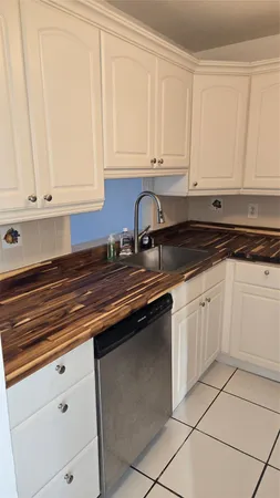 a kitchen with granite countertop white cabinets and sink