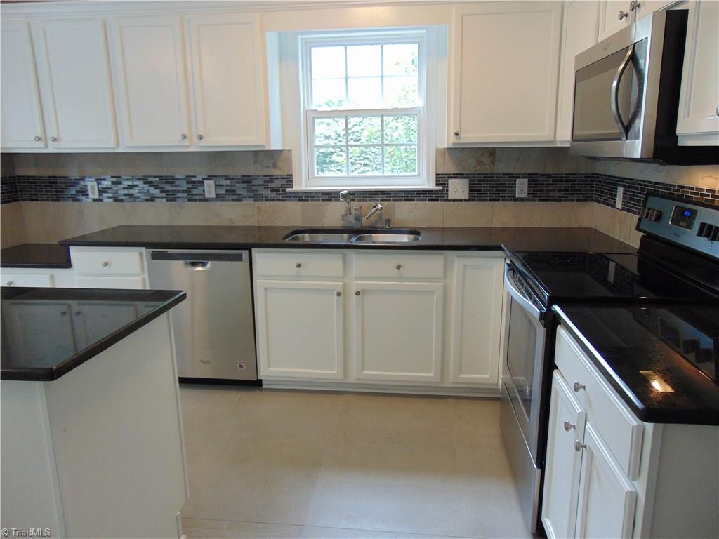 6819 Rangecrest Road Belews Creek, NC 27009 - Photo 3 of 30 Kitchen is ready to impress! Stainless Steel appliances remain. Ceramic tile floors, granite counter tops and custom tile blacksplash complete this dream kitchen!