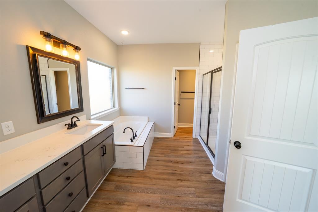 132 Addie Way Tuscola, TX 79562 - Photo 14 of 37 a bathroom with a double vanity sink a mirror and a shower