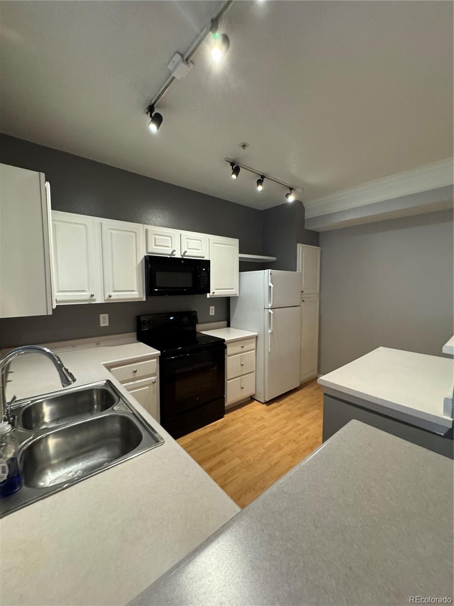 1815 Spaulding Circle Superior, CO 80027 - Photo 12 of 24 a kitchen with a refrigerator stove and white cabinets