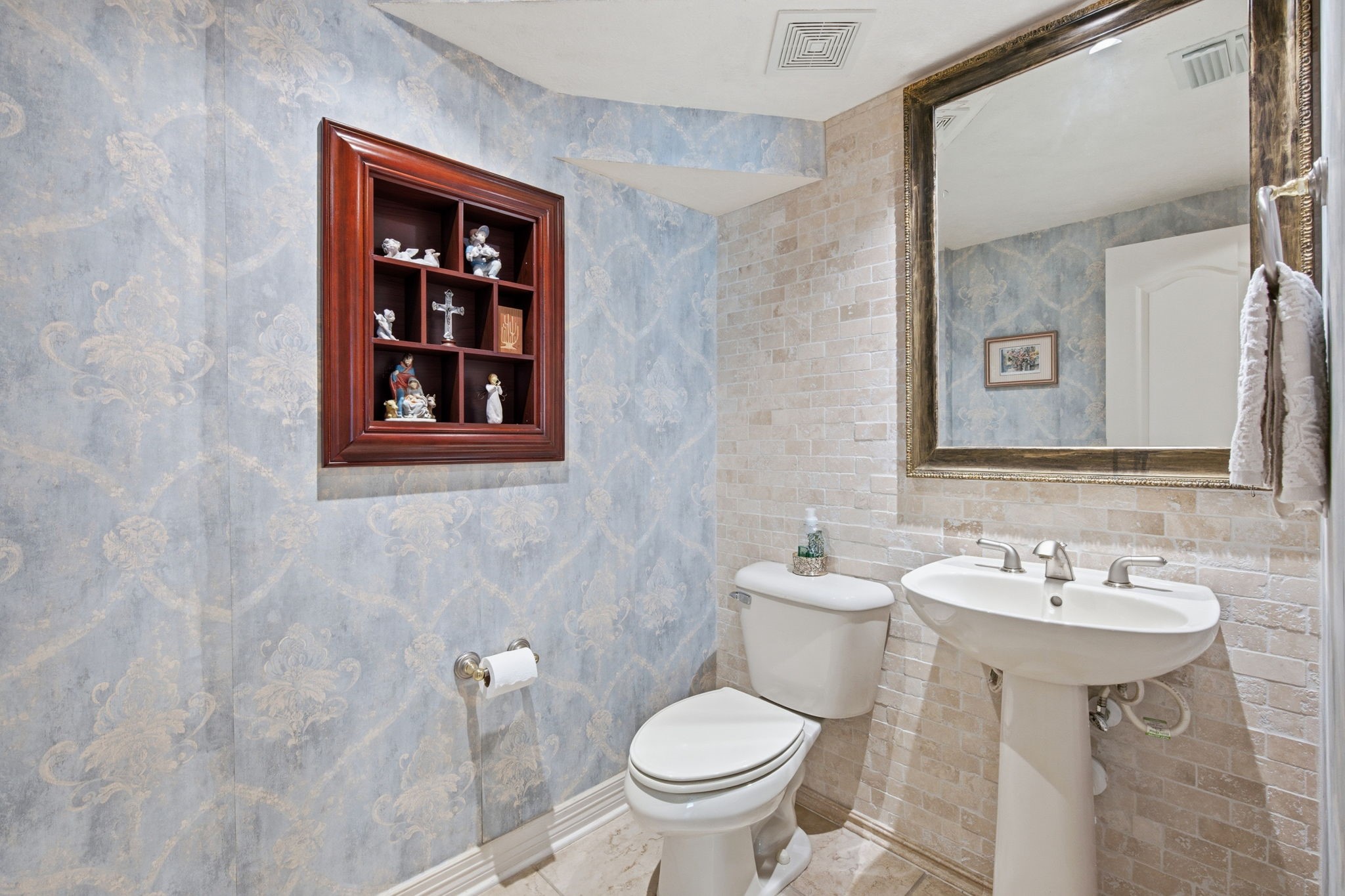 9722 Blue Cruls Way Spring, TX 77379 - Photo 7 of 45 Luxurious powder bath with on trend wallpaper and stone backplash wall of tumbled marble. Pedestal sink with newer framed mirror