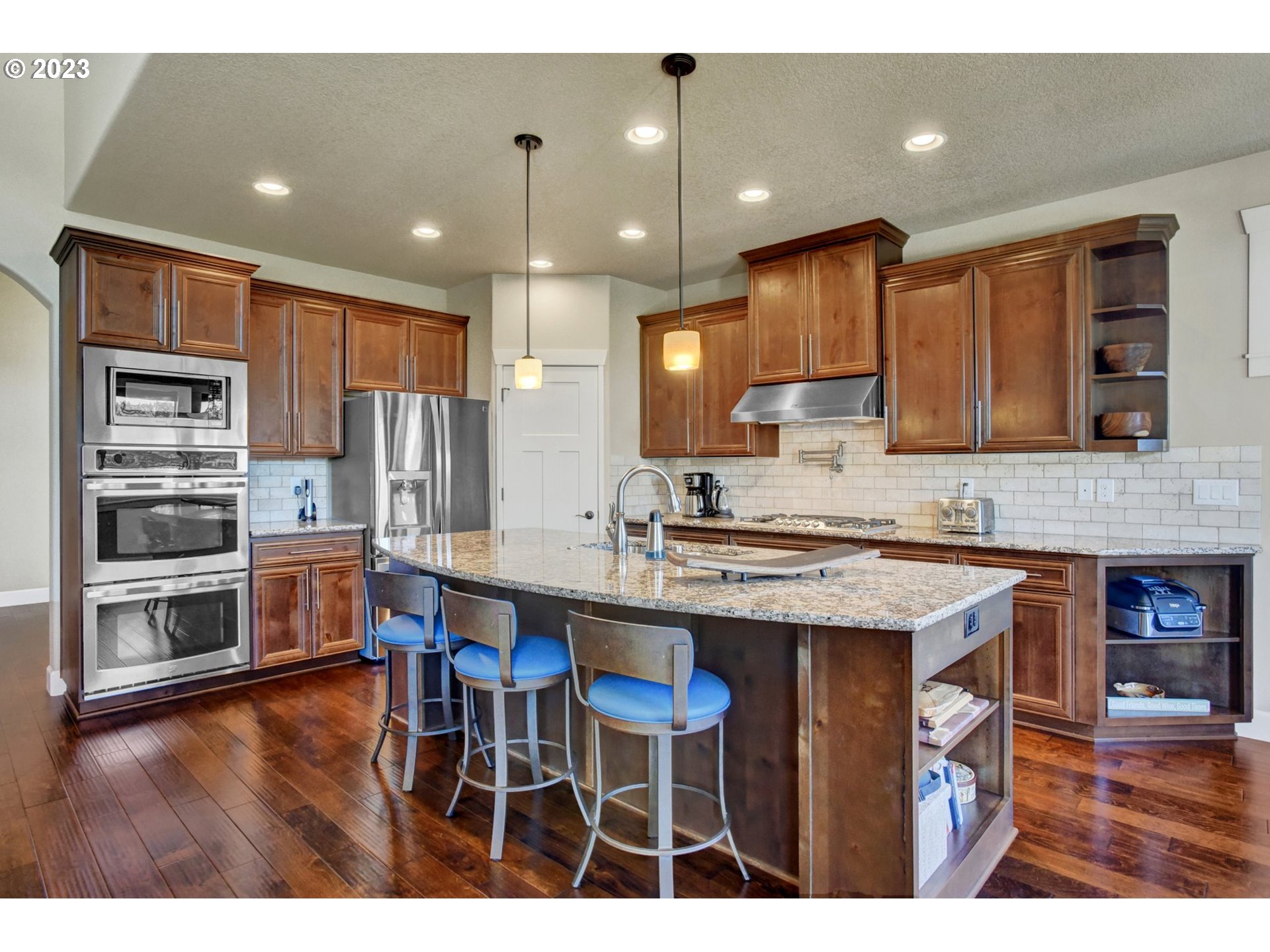 1710 South Nighthawk Road Ridgefield, WA 98642 - Photo 9 of 44 a kitchen with stainless steel appliances granite countertop a table chairs sink refrigerator and microwave