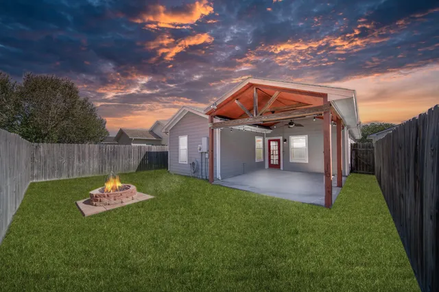 a backyard of a house with table and chairs