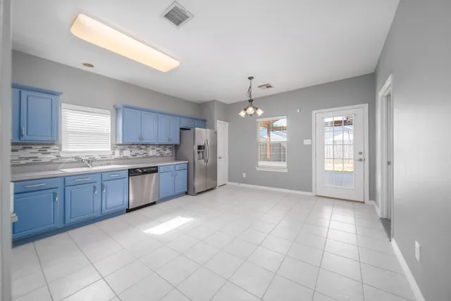 a large kitchen with cabinets and window