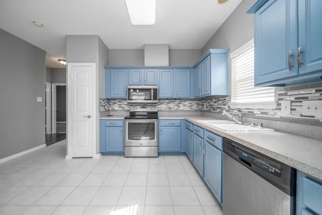 a kitchen with kitchen island granite countertop a stove sink and cabinets